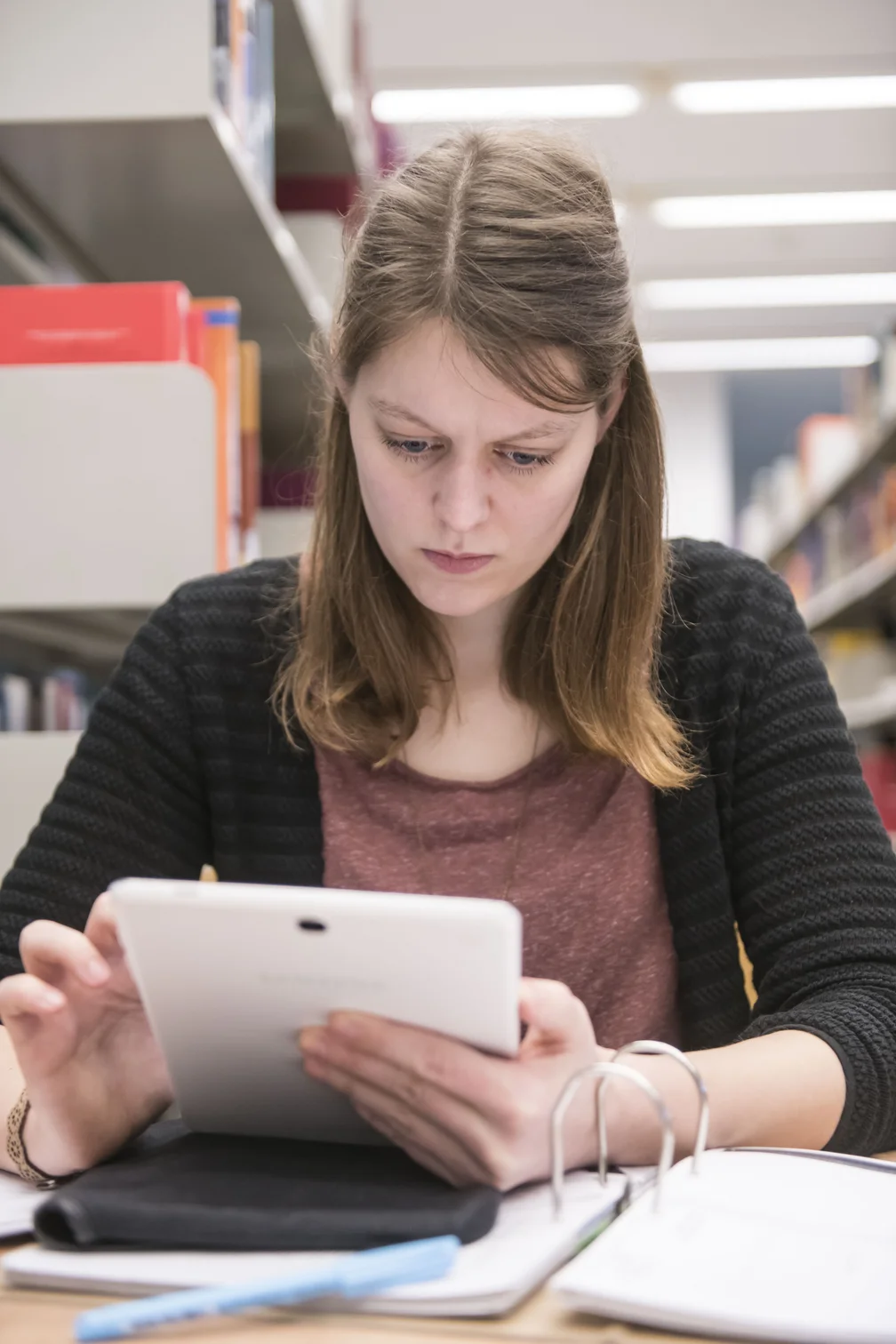 Eine junge Frau arbeitet am Tablet