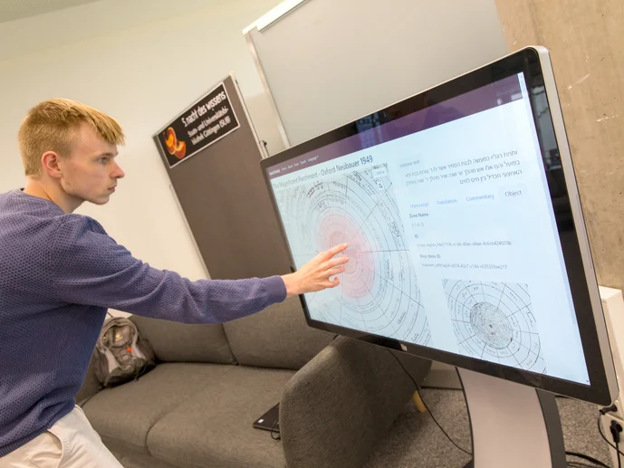 Eine Person zeigt mit einem Finger auf einen großen Bildschirm