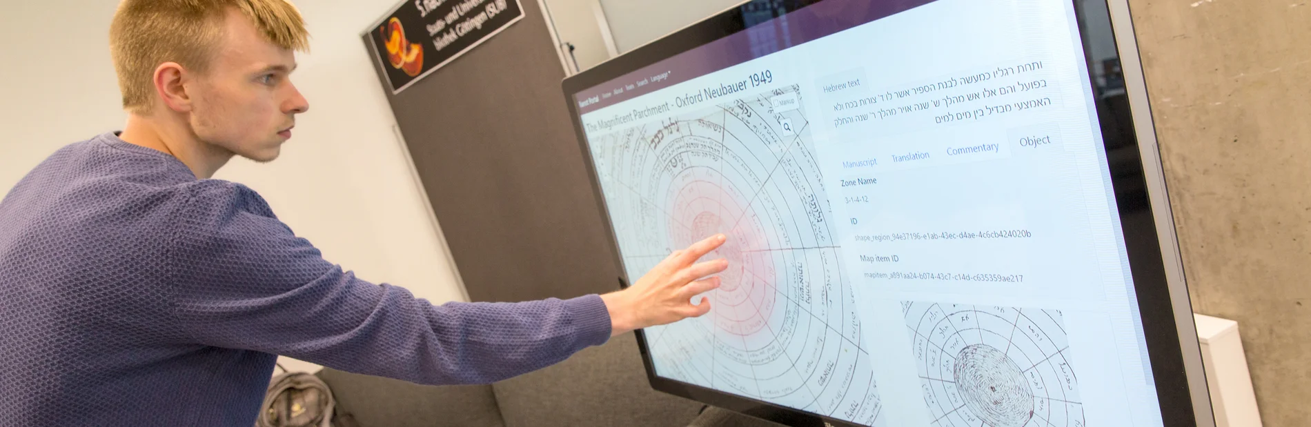 Eine Person zeigt mit einem Finger auf einen großen Bildschirm