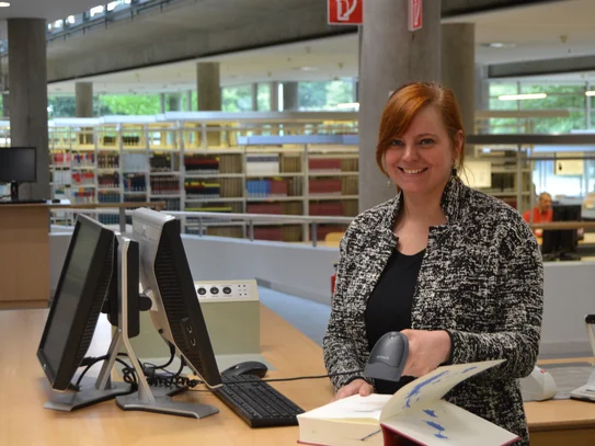 Eine junge Frau scannt ein Buch