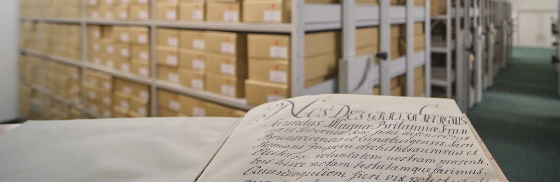 Gründungsurkunde der Universität Göttingen Gründungsurkunde der Universität Göttingen im Vordergrund, dahinter Regale mit Archivalien