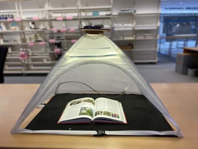 Ein Buch liegt aufgeschlagen in einem Scanzelt