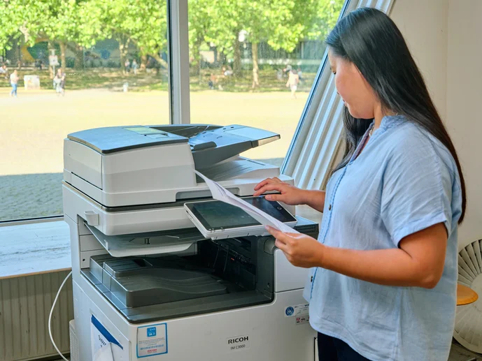 Studierende an einem Multifunktionsgerät