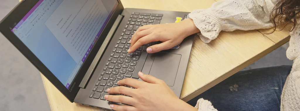 Aktuelle_Forschung_Lehre_Header20251118 Eine Person arbeitet am Laptop. Auf dem Bildschirm ist eine Textdatei geöffnet.