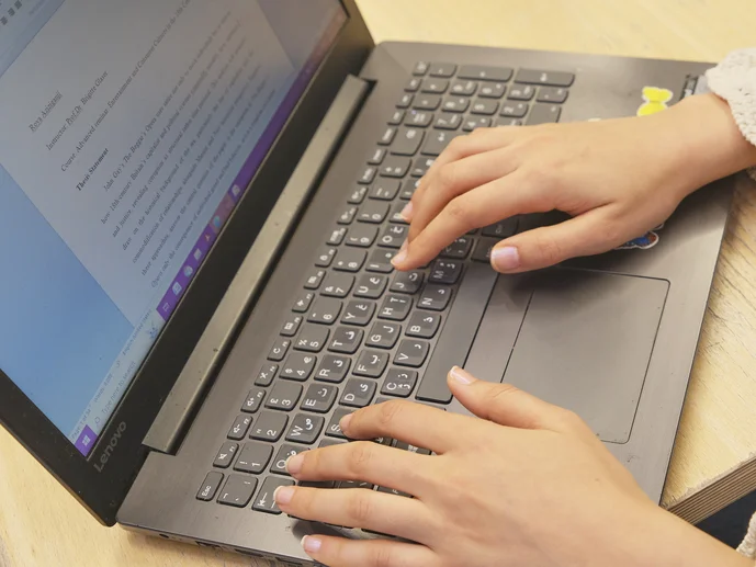 Aktuelle_Forschung_Lehre_Header20251118 Eine Person arbeitet am Laptop. Auf dem Bildschirm ist eine Textdatei geöffnet.