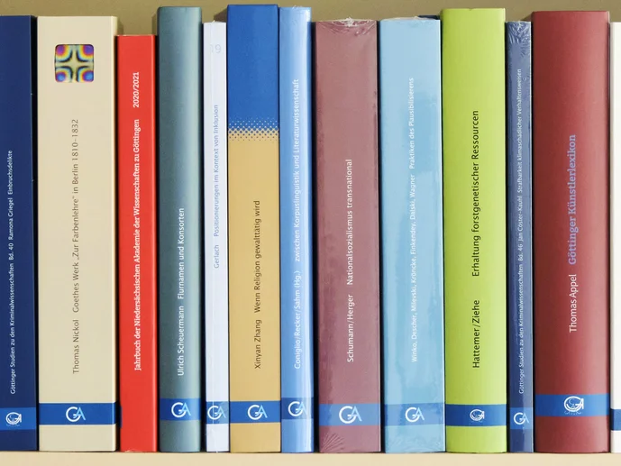 Dekorative Grafik mit mehreren Buchrücken des Universitätsverlages Göttingen