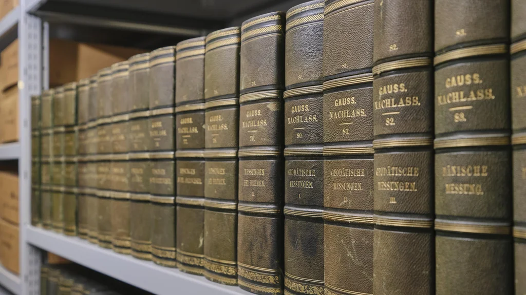 Regal mit grünen, goldverzierten Bucheinbänden mit der Aufschrift ‚GAUSS NACHLASS‘